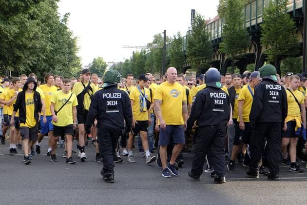 Polizeibeamte begleiten dänische Fußballfans und trennen sie von den Fans des Hertha BSC vor dem Spiel Hertha BSC - Broendby Kopenhagen im Friedrich-Ludwig-Jahn-Sportpark in Berlin-Prenzlauer Berg Polizeieinsatz beim Fußballspiel Hertha-Brondby in Berlin
