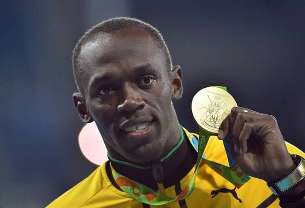 Rio 2016, Leichtathletik, 100m der Herren, Usain Bolt während der Siegerehrung Medalist Usain Bolt (JAM) shows off his third consecutive 100m gold during the Men s 100m victory ceremony in the Olympic Stadium at the 2016 Rio Summer Olympics in Rio de Janeiro, Brazil, on August 15, 2016.  OLY20160815122 KEVINxDIETSCH