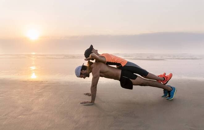 Athletes couple training on the beach at sunset, pushups model released Symbolfoto  MGOF002148