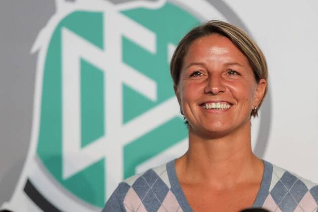 Inka Grings (Trainerin, MSV Duisburg) vor dem DFB-Logo, Porträt, Portrait, Freude, freundlich, fröhlich, strahlend, optimistisch, die einzige Frau unter 12 Trainern der 1. Liga, Fussball, Allianz Frauen-Bundesliga, Saisoneröffnung, xozx