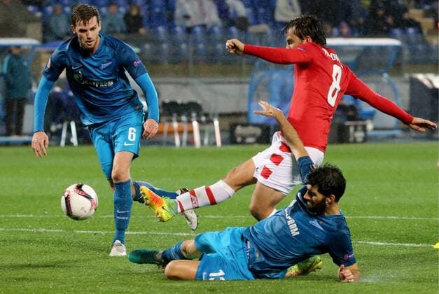 ST PETERSBURG, RUSSIA â€“ SEPTEMBER 29, 2016: FC Zenit St Petersburg s Nicolas Lombaerts (L), Kuis Neto (R) and AZ Alkmaar s Joris van Overeem (C) fight for the ball in their 2016 17 UEFA Europe League Group D Round 2 football match at Petrovsky Stadium. Alexander Demianchuk TASS  TS032CD4