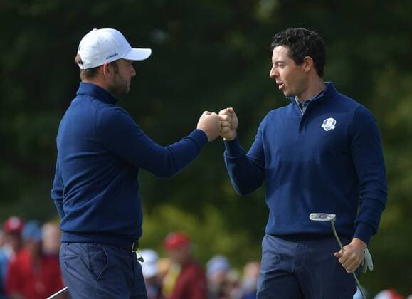 European team member Rory McIlroy (R) and Andy Sullivan celebrate after winning the 12th hole during day 1 of the 2016 Ryder Cup at Hazeltine National Golf Club in Chaska, Minnesota on September 30, 2016.  MIN20160930324 KEVINxDIETSCH