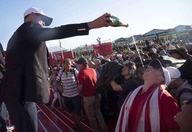 USA team member pours champaign in a fans mouth as he celebrates after the United States defeated Europe 17-11 to win the 2016 Ryder Cup at Hazeltine National Golf Club in Chaska, Minnesota on October 2, 2016. USA defeated Europe for the first time since 2008.  MIN20161002353 KEVINxDIETSCH