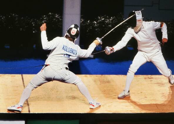 Fencing - 1992 Barcelona Olympics - Men s Epee Team, Semi-Final: Unified Team vs. West Germany Pavel Kolobkov (Unified Team) vs. Elmar Borrmann (West Germany) Kolobkov ( 83) defends at the Palace of Metallurgy. Unified Team was the name used for the sports team of the former Soviet Union Russia (except the Baltic states). Kolobkov was appointed Russian Minister of in October 2016. His predecessor Vitaly Mutko had been implicated in the state-sponsored doping detailed in the World Anti-Doping Agency s (WADA) Independent Commission. Kolobkov himself, as Deputy Sports Minister, had been barred from Wada s Foundation Board due to Russian Anti-Doping Agency (RUSADA) being declared non-compliant with the WADA code. 06 08 1992 