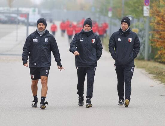 das Trainerteam geht im Gleichschritt voran, (v.li.) Dirk Schuster (Trainer FC Augsburg), Sascha Franz (Co-Trainer FC Augsburg), Frank Steinmetz (Co-Trainer FC Augsburg), auf dem Weg zum Trainingsplatz, FC Augsburg, Training, Saison 2016 - 2017, 01.11.2016