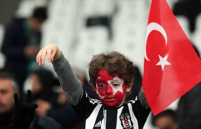 A Besiktas fan, his face painted with the colors of the Turkish flag, sits inside the Besiktas Vodafone Arena stadium prior to a Turkish Cup soccer match between Beisktas and Kayserispor, the first soccer match since Saturday s twin attacks outside and near the stadium, in Istanbul, Wednesday, Dec. 14, 2016.  Copyright: TolgaxAdanali 15582233