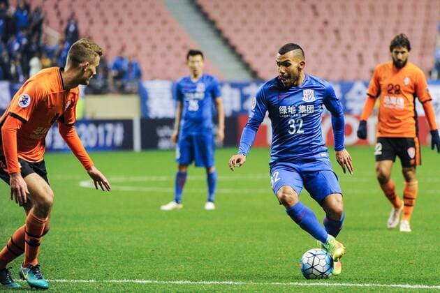 Argentine football player Carlos Tevez of China s Shanghai Greenland Shenhua F.C., right, challenges Daniel Bowles of Australia s Brisbane Roar F.C. in a qualifying match during the 2017 AFC Champions League in Shanghai, China, 8 February 2017. Carlos Tevez s debut for big-spending Chinese Super League side Shanghai Shenhua did not go as planned. In fact, it was the exact opposite as they were unceremoniously dumped out of the Asian Champions League play-off by Brisbane Road. Tevez, who moved to China from Boca Juniors for a reported ¡ê615,000-a-week and became the world s highest-paid player , couldn t help his new team-mates as they went down 2-0 in one of the biggest shocks the AFC has seen. Carlos Tevez has nightmare debut for Shanghai Shenhua as they are dumped out of AFC Champions League  20170208_36051