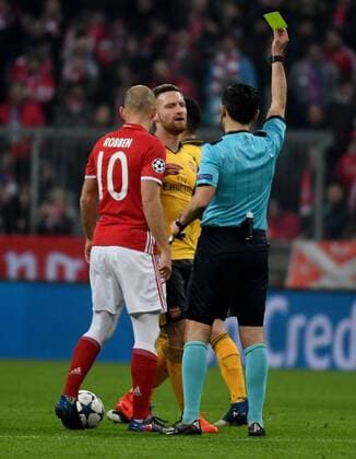 15.02.2017, xjhx, Fussball Champions League, FC Bayern Muenchen - Arsenal London, emspor, v.l. Arjen Robben (FC Bayern Muenchen), Shkodran Mustafi (Arsenal London) bekommt von Referee Schiedsrichter Milorad Mazic die Gelbe Karte fuer, receive a yellow card, gezeigt Muenchen