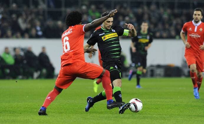 Fussball, UEFA Europe League, Herren, Saison 2016 2017, Borussia Park: Bor. Mönchengladbach (schwarz) - AC Florenz (rot); Lars Stindl (Gladbach), Carlos Sanchez (Florenz), Aktion.