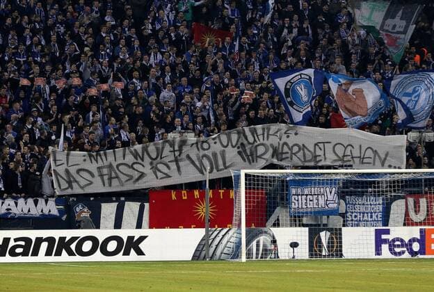 Fußball, EL, FC Schalke 04 - PAOK Saloniki, Kritik an den Anstoßzeiten 22.02.2017 - Fans vom FC Schalke 04 in der Nordkurve halten ein Plakat mit der Aufschrift E: MIT WOLFF UM 18:00 UHR? DAS FASS VOLL IHR WERDEN SCHON SEHEN hoch beim Europa League Sechzehntelfinale Rückspiel (Saison 2016 17) FC Schalke 04 - PAOK Thessaloniki. Copyright Thomas Pakusch