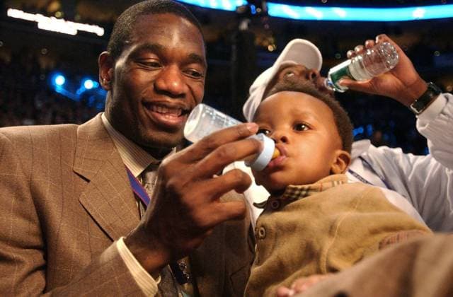 -- Saturday, February 9, 2002, Philadelpia, PA -- Dikembe Mutombo, of the Philadelphia 76ers, feeds his 11-month-old son Jean Jaques, prior to the start of the Slam Dunk competition at the First Union Center during teh NBA Basketball Herren USA All-Star weekend in Philadelphia. ( The Sacramento Bee ) The Sacramento Bee ZUMA Press Sacramento Bee Image Archive  - ZUMAG 20020922_aac_s76_997 Copyright: xHectorxAmezcuax