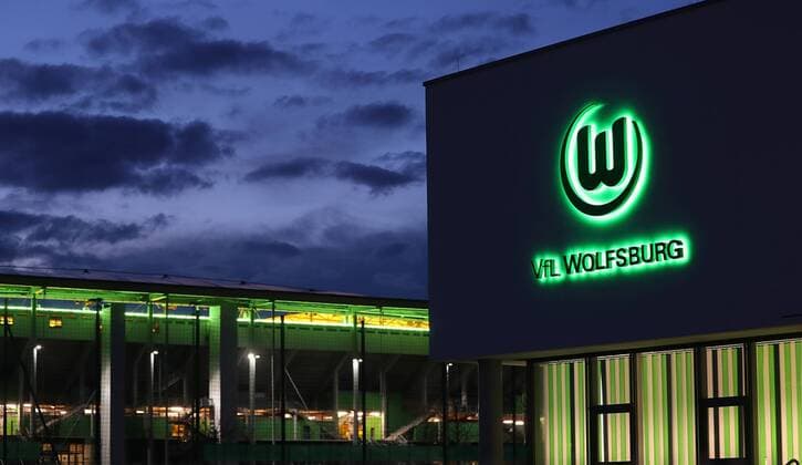 Geschäftsstelle des VfL Wolfsburg und im Hintergrund die Volkswagenarena bei Nacht
