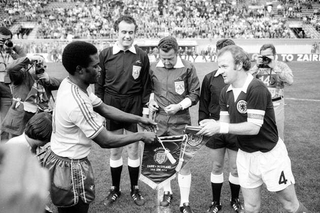 WM 1974, Wimpeltausch vor dem Spiel Zaire gegen Schottland, v.li.: Kidumu Mantantu, Linienrichter Hans Joachim Weyland, FIFA Schiedsrichter Gerhard Schulenburg (beide BR Deutschland), Billy Bremner