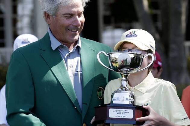 Freddie Couples watches Liam Hartling overall winner of the Boys 10-11 age group in the Drive, Chip & Putt Championship hold his trophy at the 2017 Masters Tournament at Augusta National Golf Club in Augusta, Georgia on April 2, 2017.  AUG20170402118 JOHNxANGELILLO