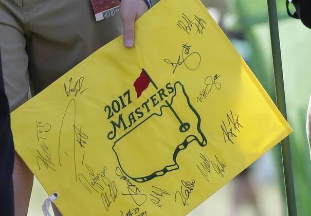 A boy holds an autographed Masters flag at a practice round at the 2017 Masters Tournament at Augusta National Golf Club in Augusta, Georgia on April 2, 2017.  AUG20170402103 JOHNxANGELILLO