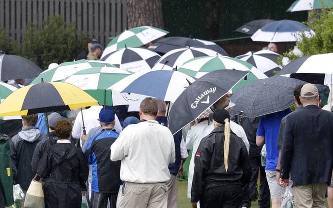 Patrons carrying umbrellas in the rain exit the grounds after the traditional par 3 contest gets canceled due to approaching rain and thunderstorms on Wednesday at the 2017 Masters Tournament at Augusta National Golf Club in Augusta, Georgia on April 5, 2017.  AUG20170405605 JOHNxANGELILLO