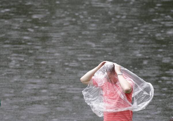 Bilder des Tages - SPORT A man covers himself in a clear rain poncho after the traditional par 3 contest gets canceled due to approaching rain and thunderstorms on Wednesday at the 2017 Masters Tournament at Augusta National Golf Club in Augusta, Georgia on April 5, 2017.  AUG20170405607 JOHNxANGELILLO