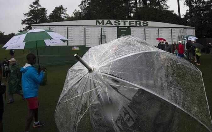 Patrons carrying umbrellas in the rain exit the grounds after the traditional par 3 contest was canceled due to approaching rain and thunderstorms on Wednesday at the 2017 Masters Tournament at Augusta National Golf Club in Augusta, Georgia on April 5, 2017.  AUG20170405301 KEVINxDIETSCH
