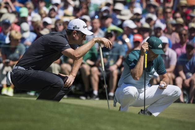 Justin Rose (L) and Sergio Garcia line up putts on the fourth green during the fourth round of the 2017 Masters Tournament at Augusta National Golf Club in Augusta, Georgia on April 9, 2017.  AUG20170409317 KEVINxDIETSCH