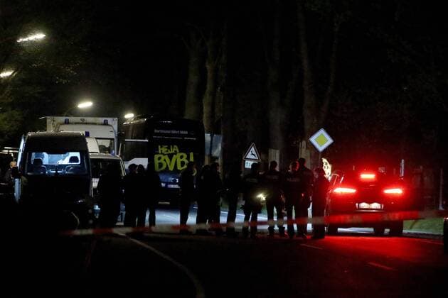 (170411) -- DORTMUND (GERMANY), April 11, 2017 -- Police officers stand guard at the site where German soccer team Dortmund s bus was damaged by explosions in Dormund, Germany, on April 11, 2017. German soccer team Dortmund said Tuesday that its Champions League match against Monaco was canceled and one player injured after explosions hit team bus. Three explosions hit Dortmund team s bus in the district of Hoechsten of the western German city of Dortmund. ) GERMANY-DORTMUND-SOCCER TEAM-BUS-EXPLOSION JoachimxBywaletz 