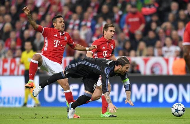 FUSSBALL CHAMPIONS LEAGUE SAISON 2016 2017 VIERTELFINALE HINSPIEL FC Bayern Muenchen - Real Madrid 12.04.2017 Thiago Alcantara (li) und Philipp Lahm (hinten, beide FC Bayern Muenchen) gegen Sergio Ramos (Mitte, Real Madrid) 