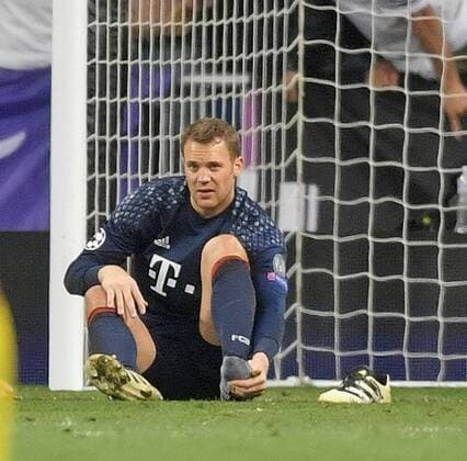 18.04.2017, Fussball Champions-League 2016 2017, Viertelfinale Rückspiel, Real Madrid - FC Bayern München, im Estadio Bernabeu in Madrid, Torwart Manuel Neuer (FC Bayern München) sitzt mit Schmerzen an seinem gebrochenen linken Fuss am Boden, hat seinen Schuh ausgezogen und fasst sich an den Fuss. 