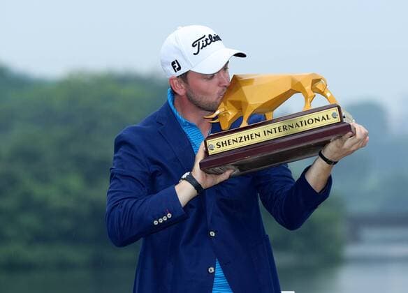 Bernd Wiesberger of Austria kisses his trophy after winning the 2017 Shenzhen International Golf Tournament in Shenzhen city, south China s Guangdong province, 23 April 2017. Austrian Bernd Wiesberger beat England s Tommy Fleetwood in a playoff on Sunday (23 April 2017) to win the Shenzhen International. Wiesberger went into the final round with a three-shot lead and eight shots ahead of Fleetwood but the Englishman fired a 63 to finish tied at 16 under. Wiesberger s 71 featured par saves on the 12th and 17th and he nearly hit the pin with his approach to the last hole but was forced to settle for a par and a trip back up the 18th. Wiesberger hit his drive in the playoff over the water off the tee and ended up in the bank while Fleetwood played safely onto the fairway and found the heart of the green with his second shot. The pressure was on Wiesberger and he delivered, placing his approach to five feet and making the putt for a birdie. Wiesberger wins playoff to capture Shenzhen International  20170423_12861