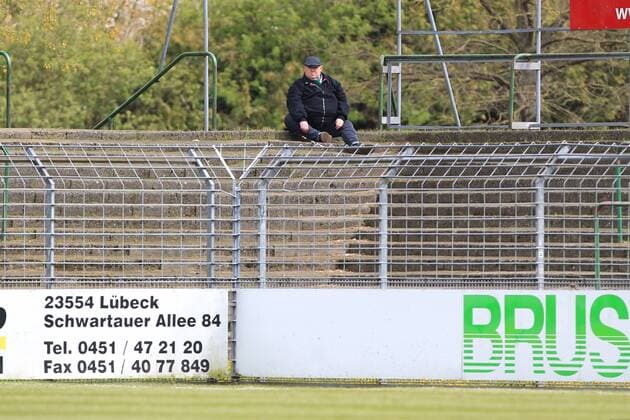 Fußball, Stadiongeschichte VfB Lübeck Ein Fan sitzt im Block D der Pappelkurve einsam auf dem Boden
