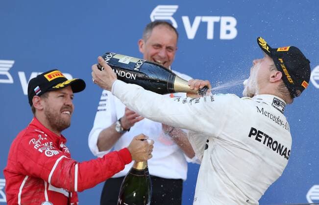 SOCHI, RUSSIA - APRIL 30, 2017: Second-placed Scuderia Ferrari F1 driver Sebastian Vettel of Germany, Mercedes Race Engineer Tony Ross, and first-placed Mercedes AMG Petronas F1 driver Valtteri Bottas of Finland, (L-R) spray champagne on the podium after the 2017 Formula One Russian Grand Prix at the Sochi Autodrom racing circuit. Alexander Demianchuk TASS  TS04A3A7