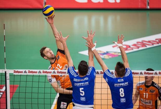 Friedrichshafen, Deutschland, 07.05.2017: Volleyball Bundesliga Saison 2016 2017 Playoff Finale Spiel 3 - VfB Friedrichshafen - Berlin Recycling Volleys. Paul Carroll (BR Volleys 12) gegen den Block aus David Sossenheimer (Friedrichshafen 5) und Georg Klein (Friedrichshafen 8)