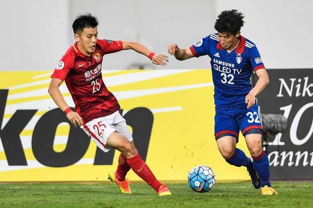 Zou Zheng of China s Guangzhou Evergrande F.C., left, challenges Kang Seong-jin of South Korea s Suwon Samsung Bluewings in a Group G during the 2017 AFC Champions League in Guangzhou city, south China s Guangdong province, 9 May 2017. Local Caption Guangzhou Evergrande competes against Suwon Samsung Bluewings at 2017 AFC Champions League  20170509_30941
