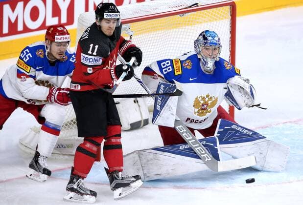 COLOGNE, GERMANY - MAY 20, 2017: Russia s Bogdan Kiselevich (L), goaltender Andrei Vasilevsky (R), and Canada s Travis Konecny in their 2017 IIHF Ice hockey Eishockey World Championship WM Weltmeisterschaft semifinal match at Lanxess Arena. Anton Novoderezhkin TASS  TS04F6CA