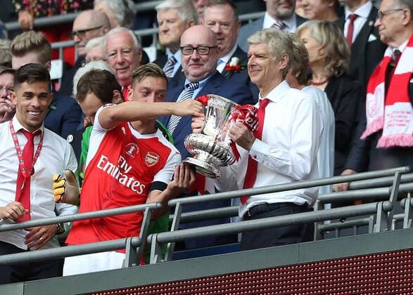 May 27th 2017, Wembley Stadium, London England; FA Cup Final, Arsenal versus Chelsea FC; Mesut Ozil of Arsenal passed the FA Cup to Arsenal Manager Manager Arsene Wenger from the stands xJohnxPatrickxFletcherx  ActionPlus11884608