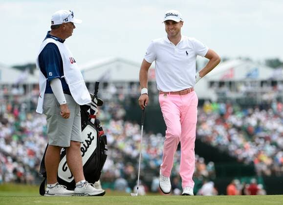 Justin Thomas (R) talks with his caddie as he waits for the group ahead on the 10th fairway during round 3 of the 117th U.S. Open golf tournament at Erin Hill golf course on June 17, 2017 in Erin, Wisconsin.  WIS20170617104 BRIANxKERSEY