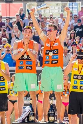 v.li.: David Poniewaz (USC Münster), Bennet Poniewaz (USC Münster); Siegerehrung; Sieger, Erstplatzierte, Goldmedaille, gold medal, BeachVolleyball, smart beach tour Dresden, xprx