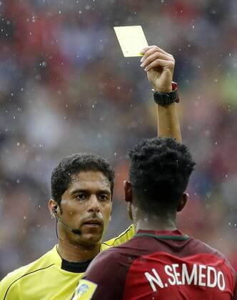 MOSCOW, RUSSIA â€“ JULY 2, 2017: Chief referee Fahad Al-Mirdasi (L) shows the yellow card to Portugalâ€™s Nelson Semedo in their 2017 FIFA Confederations Cup third place football match against Mexico at Otkrytie Arena. Mikhail Japaridze TASS  TS055C63