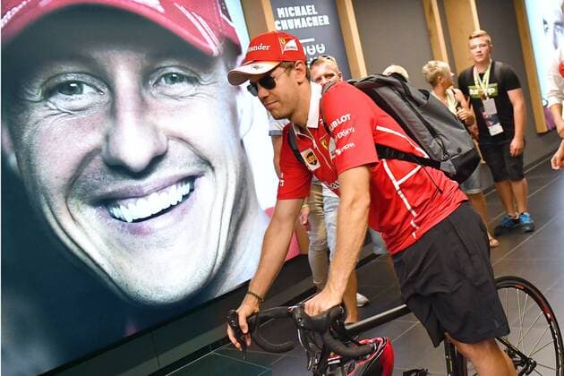 Sebastian VETTEL,GER (Scuderia Ferrari) faehrt mit seinem Rennrad an einem Portraet,Bild von Michael Schumacher vorbei. Formel 1:GP von Oesterreich, Red Bull Ring Zeltweg,Spielberg,Saison 2017,am 09.07.2017.