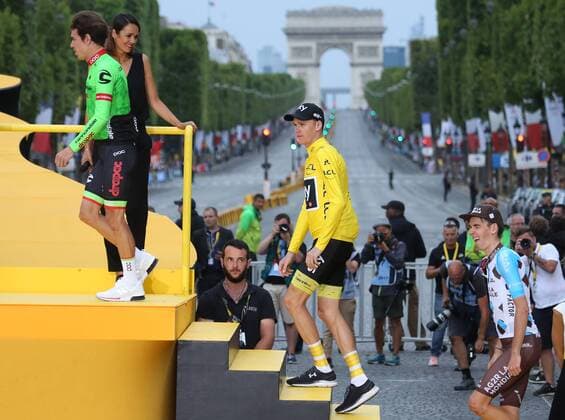 Rigoberto Uran of Colombia (L), Chris Froome of Great Britain (C) and Romain Bardet of France arrive on the presentation podium after the conclusion of the Tour de France in Paris on July 23, 2017. Froome claimed his fourth overall Tour victory.  PAR20170723042 DAVIDxSILPA
