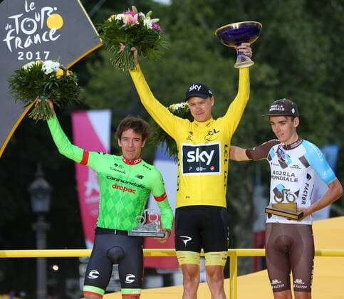 Rigoberto Uran of Colombia (L), Chris Froome of Great Britain (C) and Romain Bardet of France arrive on the presentation podium after the conclusion of the Tour de France in Paris on July 23, 2017. Froome claimed his fourth overall Tour victory.  PAR20170723046 DAVIDxSILPA