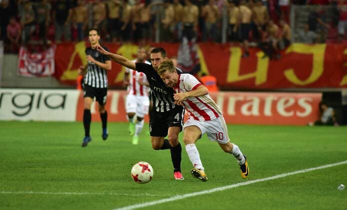 Greece: Olympiacos vs Partizan Marko Marin (no 10) of Olympiacos and Miroslav Vulicevic (no 4) of Partizan vindicate the ball during the game.  DimitriosxKarvountzis PacificxPress