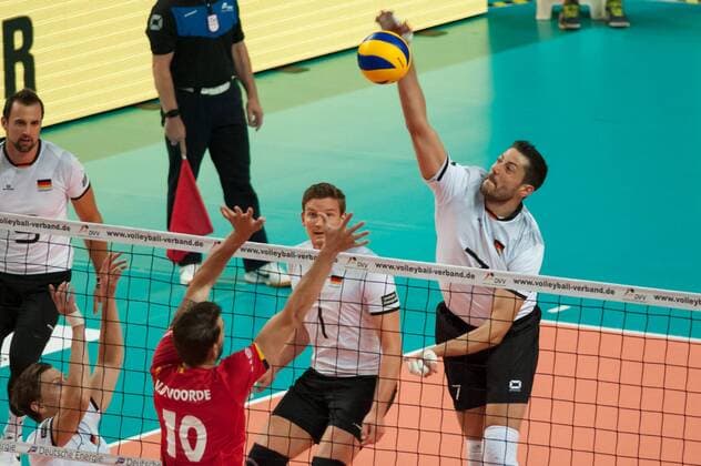 v.li.: Simon van de Voorde (Belgien, 10) mit einem Block gegen den Ball von Michael Andrei (Deutschland, 7) spielt den Ball über das Netz, Volleyball, Länderspiel, Deutschland - Belgien, xobx