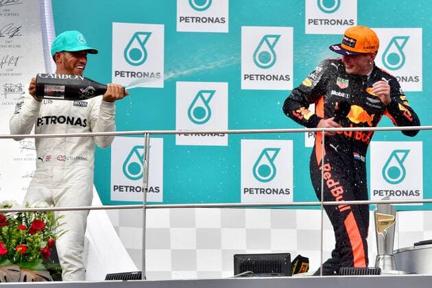 (171001) -- SEPANG, Oct. 1, 2017 -- Mercedes driver Lewis Hamilton (L) of Britain pours champagne on Red Bull driver Max Verstappen on the podium after the Formula One Malaysia Grand Prix at the Sepang Circuit in Malaysia, on Oct. 1, 2017. Max Verstappen claimed the title of the event. ) (SP)MALAYSIA-SEPANG-F1 ChongxVoonxChung 