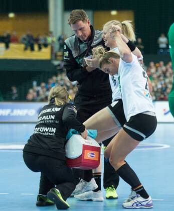Kim Naidzinavicius 15 GER is injured and has to be carried off the pitch by team doctor Dr Marcus Laufenberg and player Angie Geschke 26 GER Preliminary round Group match Germany Cameroon in Leipzig on 01 12 2017 Handball 23 Womens Handball World Cup Germany 2017