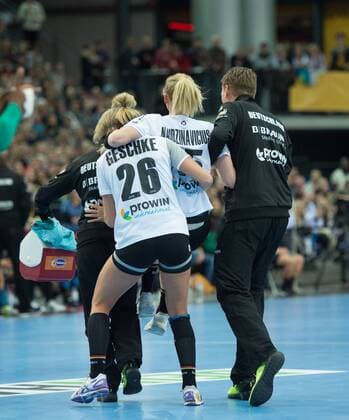 Kim Naidzinavicius 15 GER is injured and has to be carried off the pitch by team doctor Dr Marcus Laufenberg and player Angie Geschke 26 GER Preliminary round Group match Germany Cameroon in Leipzig on 01 12 2017 Handball 23 Womens Handball World Cup Germany 2017