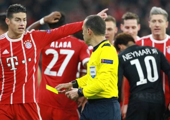 Referee Cüneyet Cakir shows James Rodriguez the yellow card Soccer UEFA Champions League FC Bayern Munich Paris Saint Germain 05 12 2017