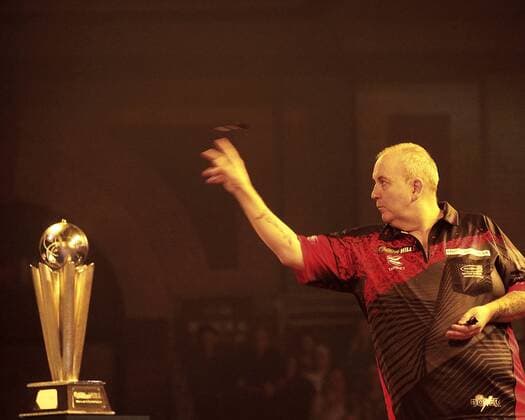 01 01 2018. London, United Kingdom. World Darts Championships Final between 2 Englishmen Phil Taylor-Rob Cross. It is Taylors last championships which he has won over 30 years,before he retires, it is Rob Cross first Championship final.Alexandra Palace. Phil Taylor throws his dart with at left the Sid Waddell trophy which the winner will receive.  xMAXxNASHx IIM-16696-0002