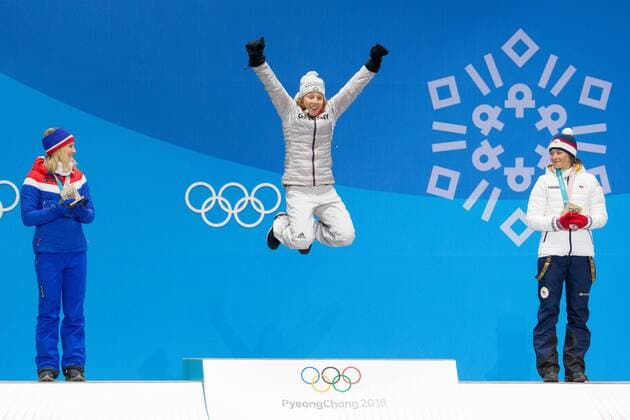 Women s 7.5m sprint biathlon gold medalist Laura Dahlmeier of Germany (C) leaps on the podium during a medal ceremony for the Pyeongchang 2018 Winter Olympics, at the Olympic Medal Plaza in Daegwalnyeong, South Korea, on February 11, 2018. Looking on are silver medalist Marte Olsbu of Norway (L) and bronze medalist Veronica Vitkova of the Czech Republic.  OLY20180211137 MATTHEWxHEALEY