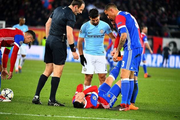 13th February 2018, St Jakob Park, Basel, Switzerland; UEFA Champions League football, round of 16, first leg, FC Basel versus Manchester City; Sergio Aguero of Manchester City and Leo Lacroix of FC Basel help out Blas Riveros of FC Basel who was suffering from cramp  ActionPlus11986712