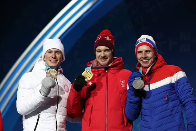 PYEONGCHANG, SOUTH KOREA â€“ FEBRUARY 16, 2018: Bronze medallist Denis Spitsov, Olympic Athlete from Russia, gold medallist Dario Cologna of Switzerland, and silver medallist Simen Hegstad Krueger of Norway, from left, pose at a victory ceremony for the men s 15km freestyle cross-country skiing race at the 2018 Winter Olympic Games Olympische Spiele Olympia OS Valery Sharifulin TASS  TS074312