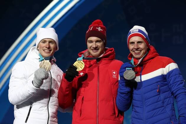 PYEONGCHANG, SOUTH KOREA â€“ FEBRUARY 16, 2018: Bronze medallist Denis Spitsov, Olympic Athlete from Russia, gold medallist Dario Cologna of Switzerland, and silver medallist Simen Hegstad Krueger of Norway, from left, pose at a victory ceremony for the men s 15km freestyle cross-country skiing race at the 2018 Winter Olympic Games Olympische Spiele Olympia OS Valery Sharifulin TASS  TS074315